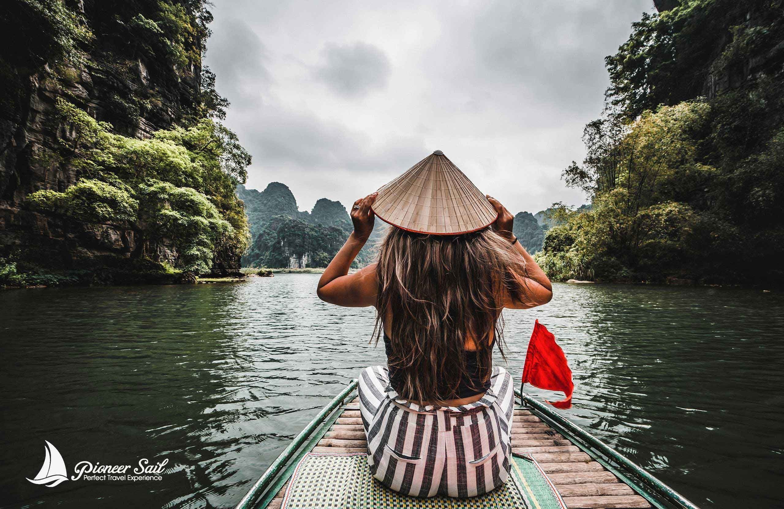 A Beautiful Vietnamese Woman Rides A Traditional Boat Through The Mountains And Jungle Of Northern Vietnam