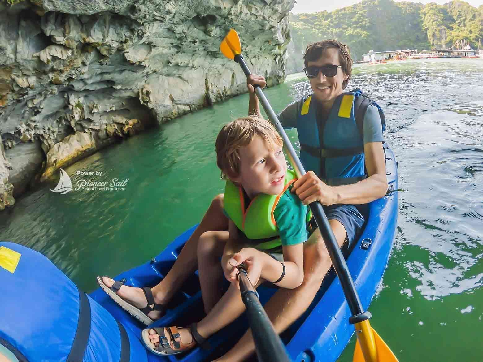 Dad And Son Travelers Rowing On A Kayak In Halong Bay Vietnam