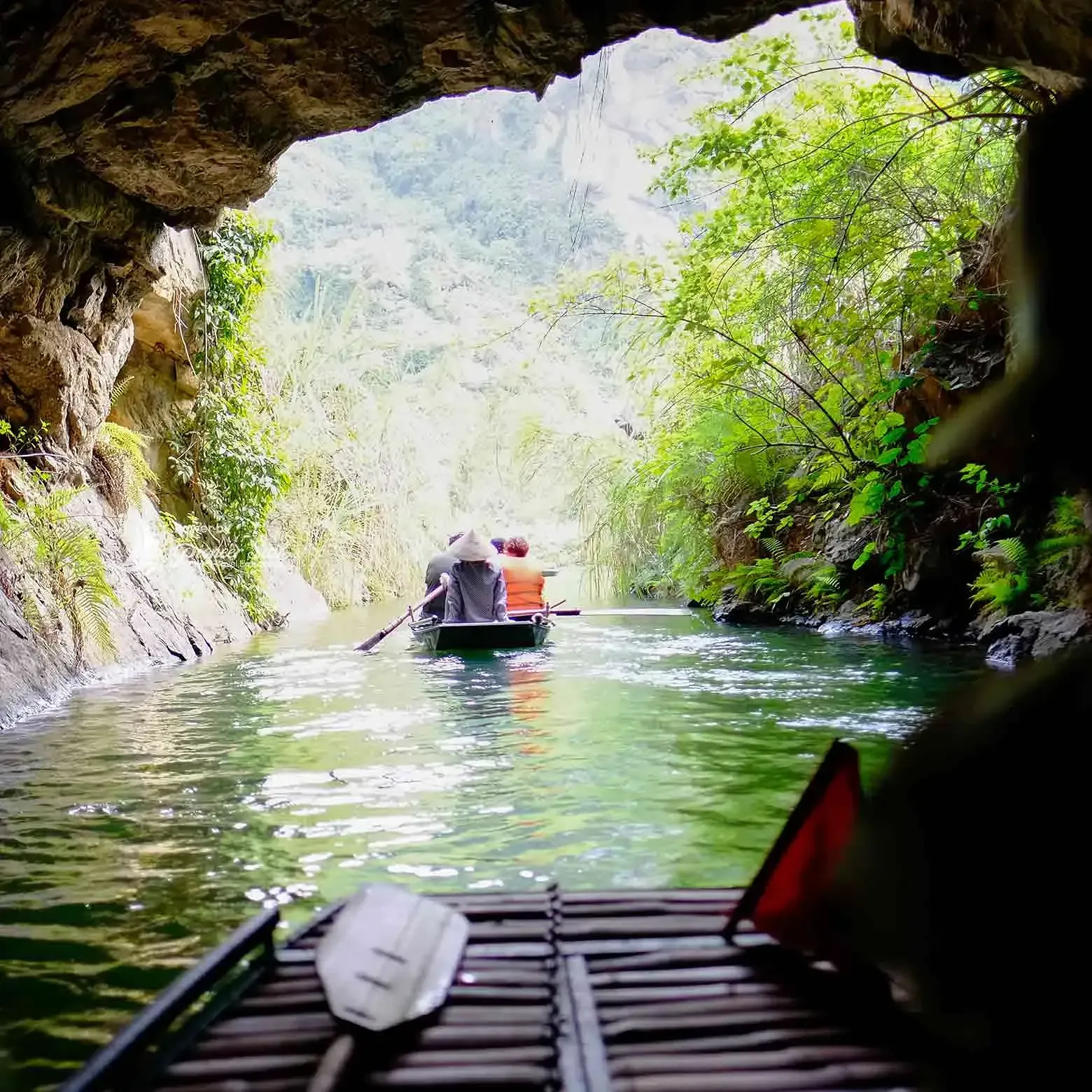 Trang An Grottoes Ninh Binh Vietnam Woman In Conical Hat Rows A Boat Of Tourists Out Of A Cave